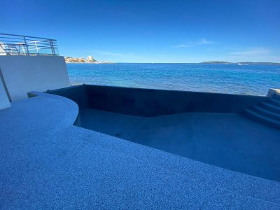 Piscine à débordement face à la mer, revêtement Aquabright bleu nuit