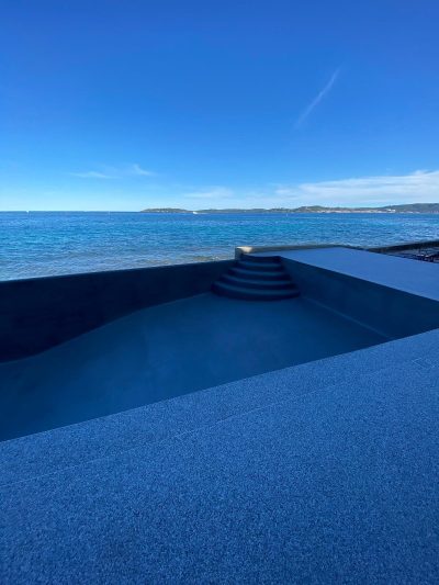 Piscine à débordement face à la mer, revêtement Aquabright bleu nuit
