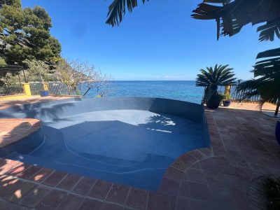 Piscine à débordement face à la mer, revêtement Aquabright bleu nuit