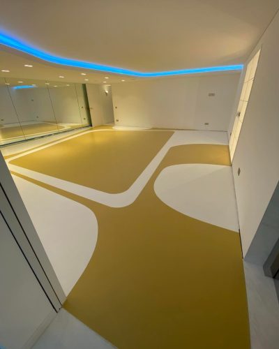 Sol en résine coulée bicolore dans une salle de sport privée