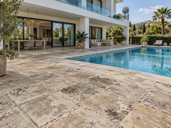 Terrasse de piscine en dallage de pierre fissuré et taché
